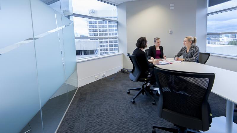 Image of three professional women having a meeting at a table in an office setting