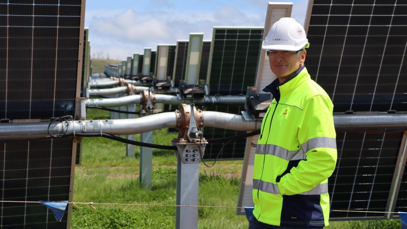 Photograph of Tim from AECN Australia in front of solar panels